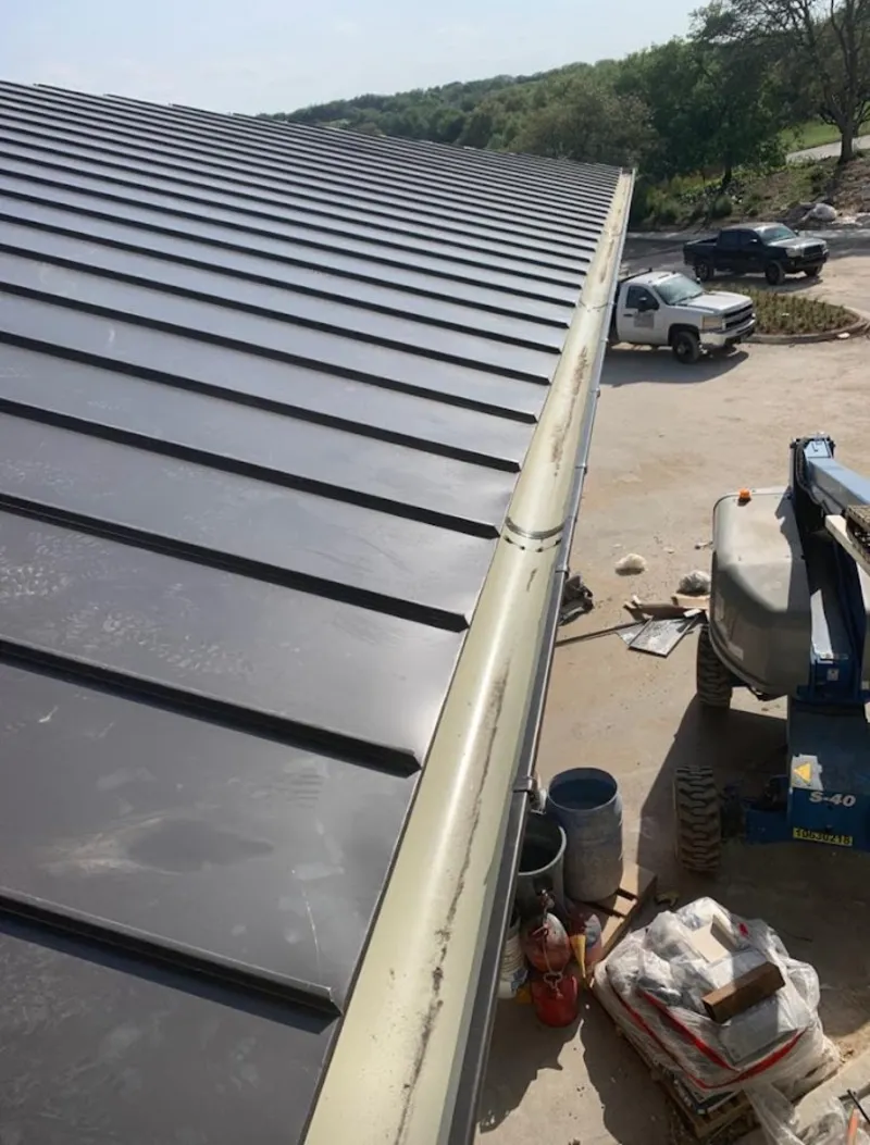 Standing seam panel and gutter detail on a metal roofing jobsite in Robeson